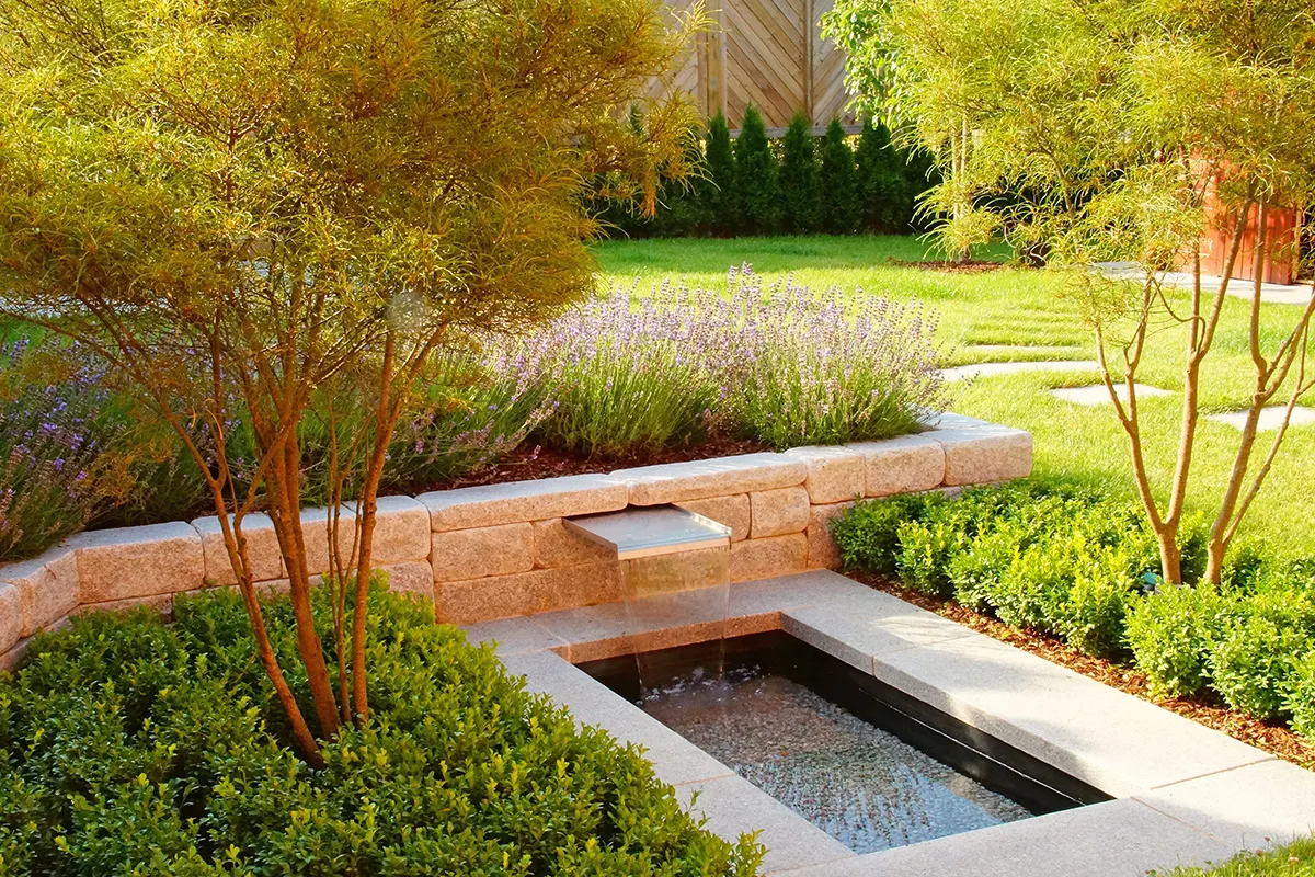 Gartenanlage mit Springbrunnen und Formgehölzen